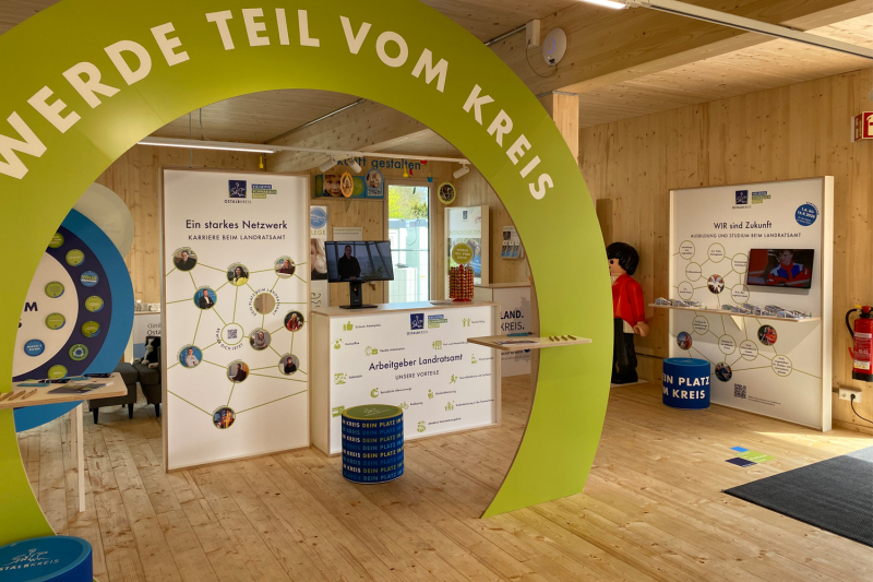 Innenansicht Kreispavillon mit einem großen Holzbogen, auf dem 'Werde Teil vom Kreis' steht.